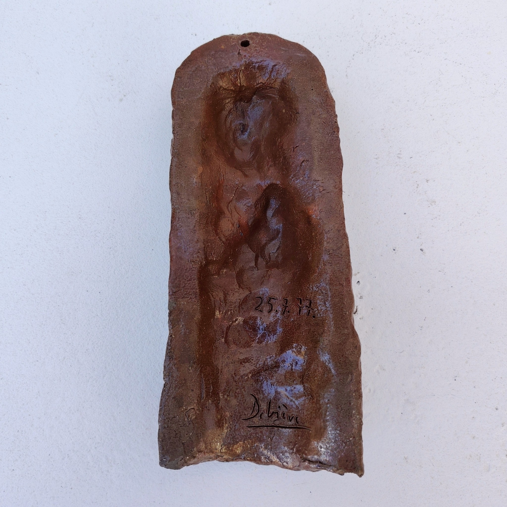 Sculpture anthropomorphe représenatnt Saint jean avec un oiseau en terre cuite vernisée, par Raymond Debiève. Un trou sur le haut pour l'accrocher au mur. Signé et daté en creux.