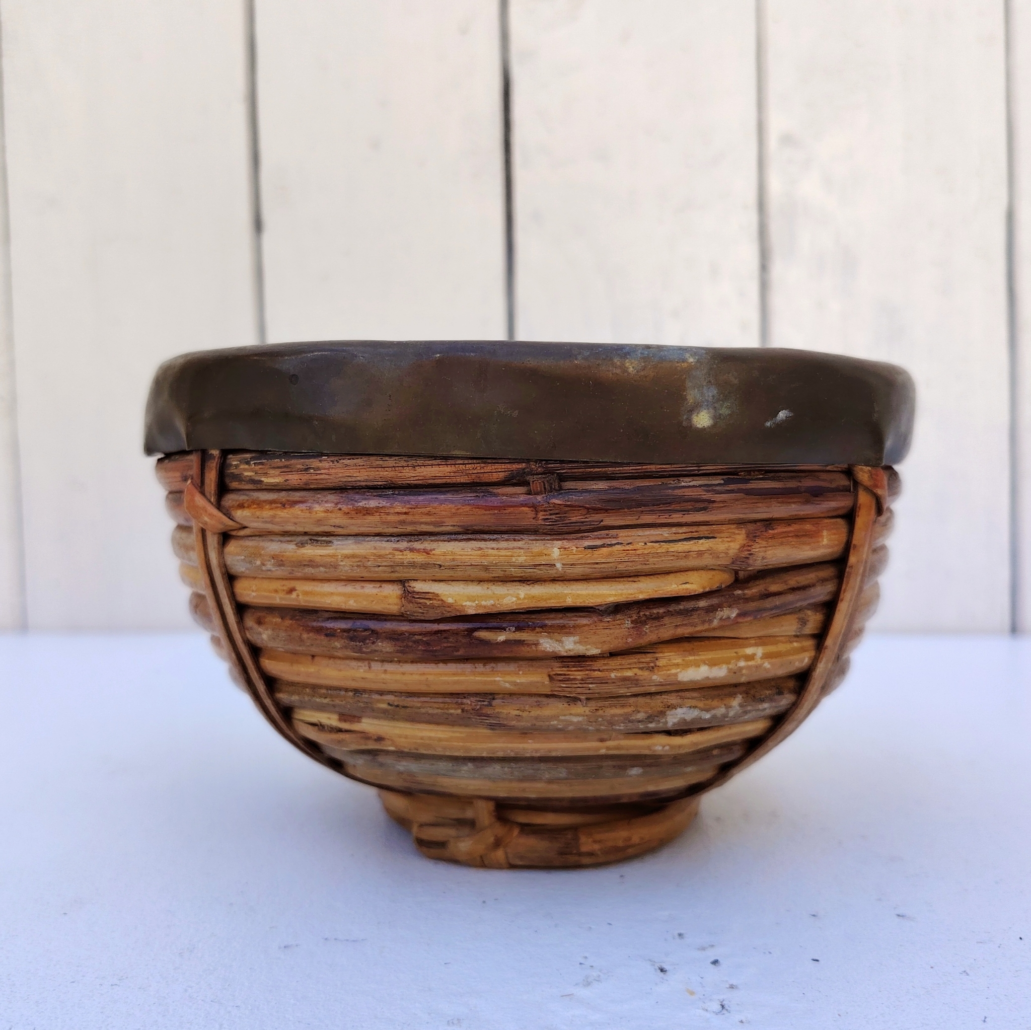 Panière en rotin finissant par un col en laiton doré, faisant penser au travail de Gabriella Crespi. Petites usures du rotin sans gravité , traces d'oxydation sur le laiton. Bon état général Hauteur : 9,5 cm Diamètre : 15 cm