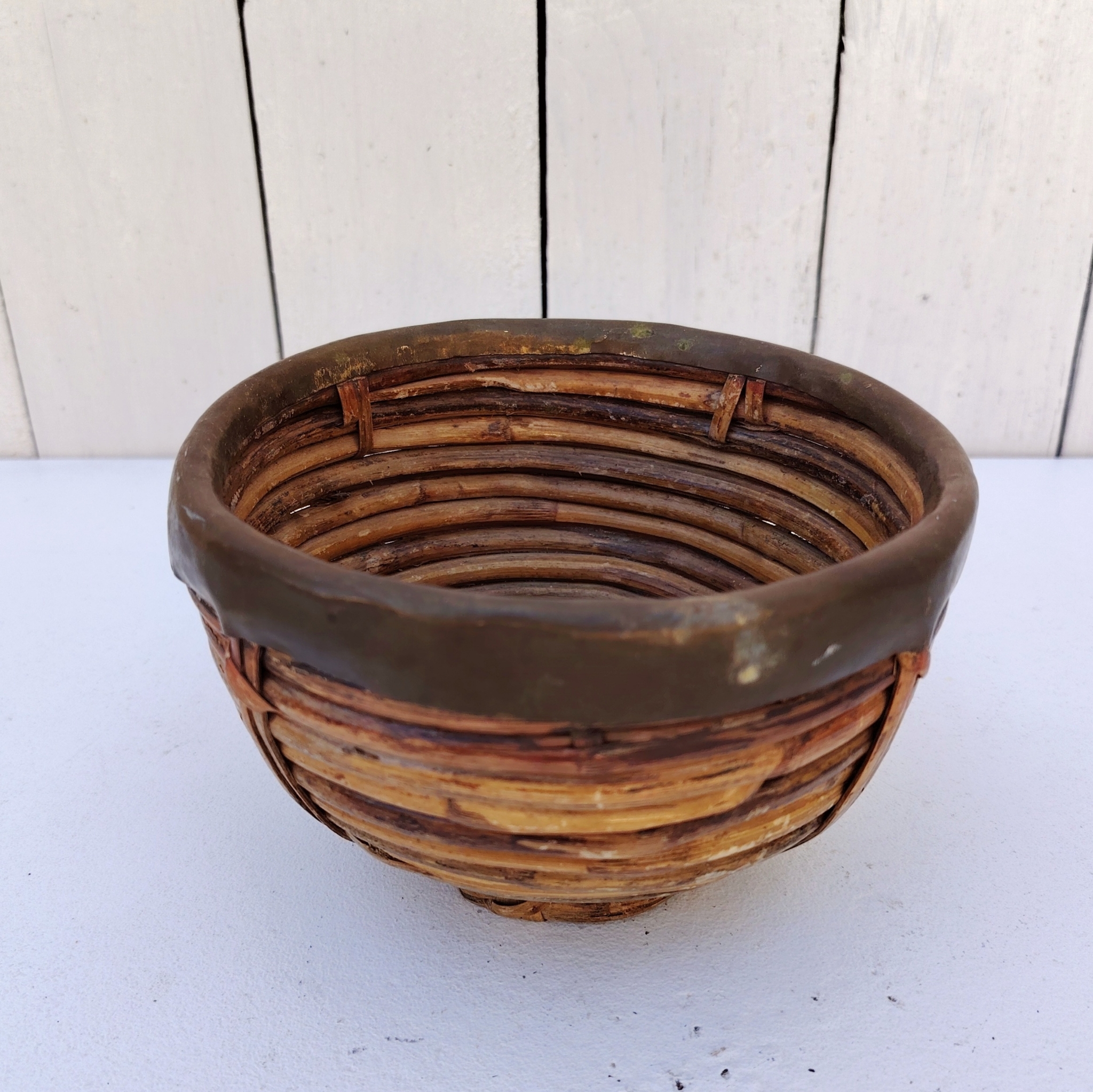 Panière en rotin finissant par un col en laiton doré, faisant penser au travail de Gabriella Crespi. Petites usures du rotin sans gravité , traces d'oxydation sur le laiton. Bon état général Hauteur : 9,5 cm Diamètre : 15 cm