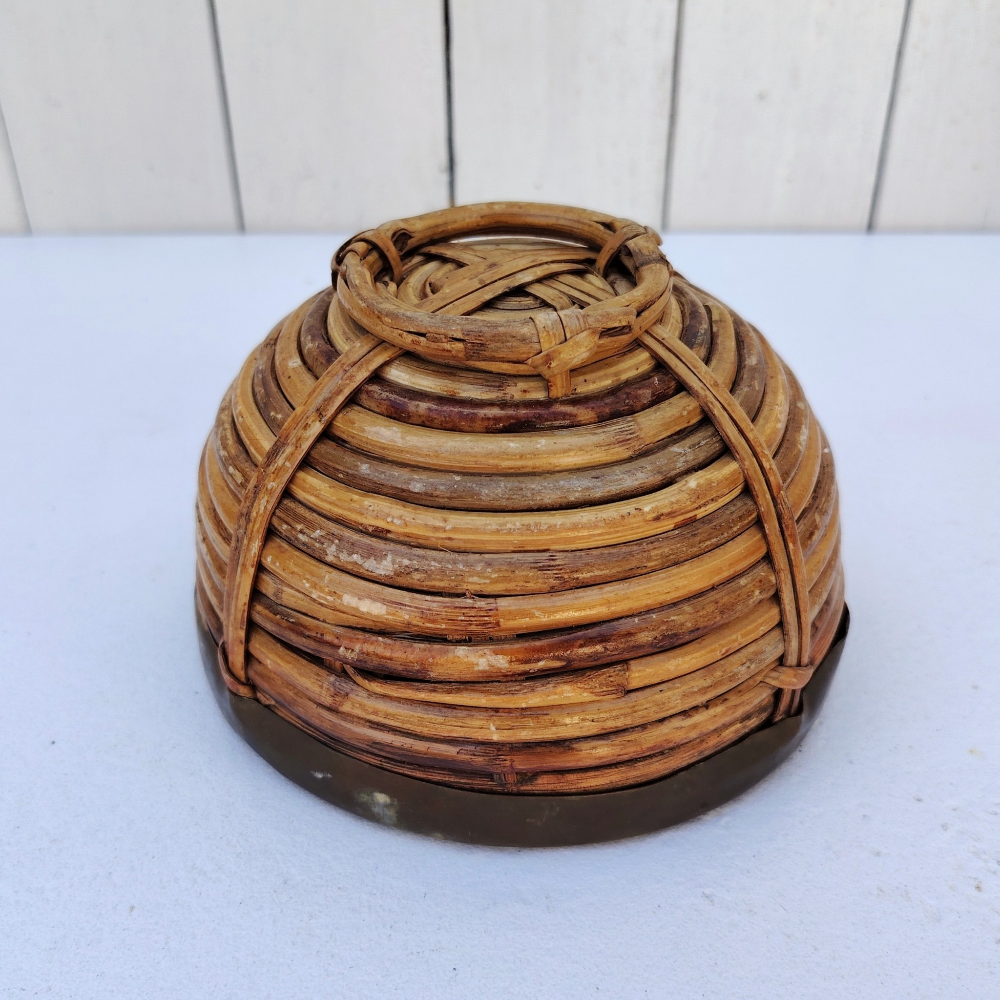 Panière en rotin finissant par un col en laiton doré, faisant penser au travail de Gabriella Crespi. Petites usures du rotin sans gravité , traces d'oxydation sur le laiton. Bon état général Hauteur : 9,5 cm Diamètre : 15 cm