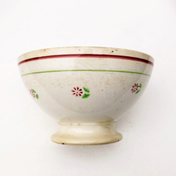 Très grand bol en faïence à décor de fleurs et liserés vert et rouge.  Usure du contour, rayure et traces d'usage . Capacité : 1 litre. Dans son jus Hauteur : 11 cm Diamètre : 18 cm