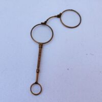 Lorgnette de théâtre pliante , en laiton doré, branche à décor ciselé. Petites rayures d'usage sur les verres. Bon état général . Longueur : 12,5 cm