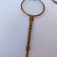 Lorgnette de théâtre pliante , en laiton doré, branche à décor ciselé. Petites rayures d'usage sur les verres. Bon état général . Longueur : 12,5 cm