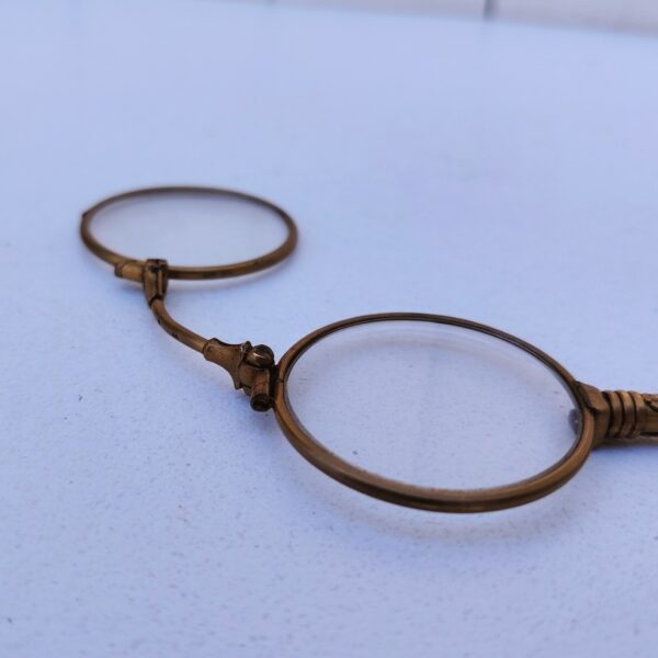 Lorgnette de théâtre pliante , en laiton doré, branche à décor ciselé. Petites rayures d'usage sur les verres. Bon état général . Longueur : 12,5 cm