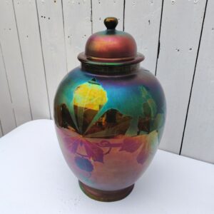 Grand pot couvert en céramique irisée , époque art déco. Décor de feuilles. Signé Montières. Quelques frottements. Très bon état. Hauteur avec couvercle : 41 cm Circonférence : 78  cm soit ( 25 cm de diamètre au plus large)