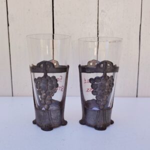 Paire d'anciens verres à Riesling souvenir d'Alsace de style art nouveau,  cerclés d'étain et écriture émaillée. Décor de grappes de raisin en étain. Bon état général. Hauteur : 11,5 cm Diamètre : 5,5 cm