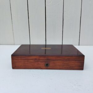 Boite en bois vernis pour ranger des bijoux, des lettres etc.... Il manque sa clé. Revêtement papier à l'intérieur déchiré. rayures et taches d'usage. Bon état général Dimensions : 21 x 12,5  cm Hauteur fermée : 4,5 cm