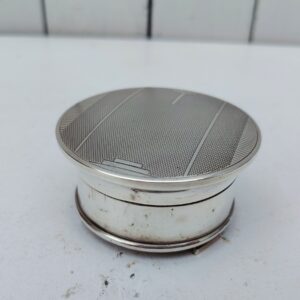 Pilulier ou petit baguier anglais , en argent Mappin & Webb. Repose sur trois petits pieds, satin et velours à l'intérieur. Signé sur le dessous, Taches sur le satin et velours. Bon état général. Hauteur fermé : 3 cm Diamètre : 7 cm