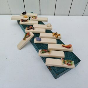Boite de douze porte couteaux en céramique sur le thème des poissons , coquillages et crustacés. Provenant probablement de Vallauris. Une petite égrenure sur l'étoile de mer. Bon état général Dimensions porte couteaux : 9,5 x 2,5 x 3 cm Dimensions boite :38,5 x 10,5 x 4 cm