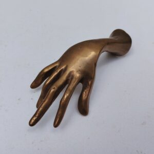 Main en bronze par Yves Lohé pouvant servir de presse papier. Signé sous le poignet. Des petites griffure d'usage Très bon état. Dimensions : 17 x 5 x 4 cm