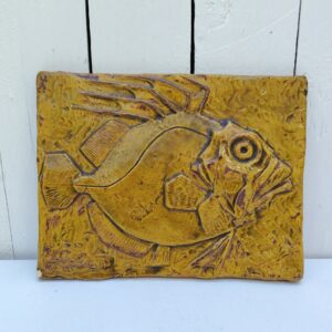 Carreau céramique par Goualc'h à Kerbigot en Bretagne. Représentant un poisson en relief. Décoration mural avec point d'accroche sur l'arrière. Un éclat sur le coin bas gauche. Signé en bas à gauche. Bon état général. Dimensions : 25 x 19 cm
