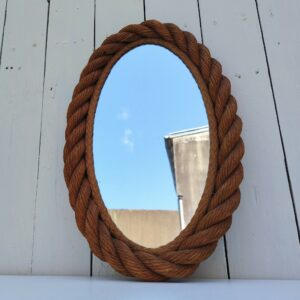Miroir ovale cerclé de corde datant des années 60, créé par Audoux Minet. Un point d'accroche sur l'arrière. Petites rayures d'usage sur le miroir sans gravité. Bon état  général. Dimensions : 42 x 25 cm