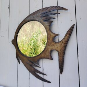 Miroir à la forme de poisson en feuille d'acier découpée et martelée pour former les écailles. Décoration vintage. Une nageoire sous la bouche est tordue. Bon état général Dimensions globales : 38 x 42 cm Diamètre miroir : 23 cm