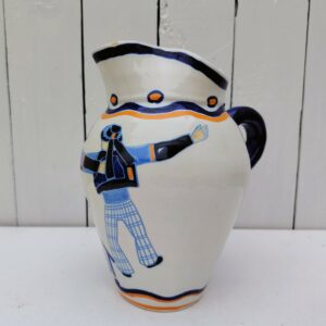 Pichet à cidre en faïence de Quimper signé Henriot, par René-Yves Creston, vers 1920. A décor de deux bretons de dos, s'en allant bras dessus bras dessous. Marqué "Gist" dans la partie basse. Signé au monogramme RYC à côté de l'anse.