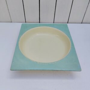 Plat creux ou légumier en faïence blanche et turquoise, Un rond dans un carré apporte une forme très élégante à ce plat. Créer par Jean Luce* . Trace d'usage , petites rayures et traces de frottement. Bon état général. Dimensions : 29,5 x 26 cm hauteur : 6 cm * Jean Luce (Jean Luce est, à 30 ans à peine, le seul créateur spécialiste des arts de la table à posséder un espace personnel à l'Exposition internationale des arts décoratifs et industriels modernes de Paris en 1925)
