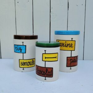 Trois pots de taille différentes en céramique datant des années 60, par Elchinger. Comprenant le pot (Sucre, sel, farine ou pâtes au choix) , le pot ( riz , semoule, chicorée café au choix ) et le pot (chocolat ou thé) Un éclat sur le couvercle du pot riz,semoule... Signé sur le dessous. Bon état général . Hauteurs avec couvercle : 17, 15 et 13 cm Diamètres : 10,5, 10,5 et 8 cm