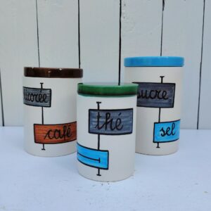 Trois pots de taille différentes en céramique datant des années 60, par Elchinger. Comprenant le pot (Sucre, sel, farine ou pâtes au choix) , le pot ( riz , semoule, chicorée café au choix ) et le pot (chocolat ou thé) Un éclat sur le couvercle du pot riz,semoule... Signé sur le dessous. Bon état général . Hauteurs avec couvercle : 17, 15 et 13 cm Diamètres : 10,5, 10,5 et 8 cm