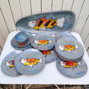 Service à poisson en faïence de Niderviller à décor de Poissons. Service comprenant un plat, une saucière  et douze assiettes.  Des petites égerenures sans gravité, des petits défauts de cuisson. Bon état général. Dimension plat : 61,5 x 26 cm Diamètre assiette : 25 cm