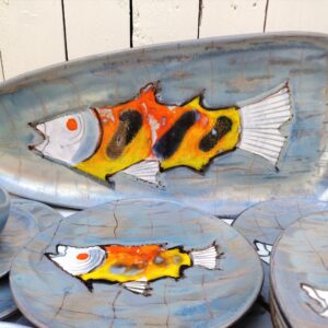 Service à poisson en faïence de Niderviller à décor de Poissons. Service comprenant un plat, une saucière  et douze assiettes.  Des petites égerenures sans gravité, des petits défauts de cuisson. Bon état général. Dimension plat : 61,5 x 26 cm Diamètre assiette : 25 cm