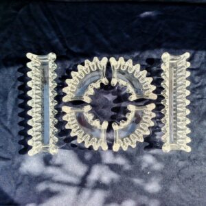 Chemin de table en cristal composé de six pièces. Elégance à la française pour une décoration de table réussie. Excellent état. Dimensions des longues pièces : 24,5 x 7 x 4,5 cm Dimensions des courbées : 15,5 x 7 x 4,5 cm