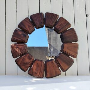 Beau miroir représentant un fleur datant des années 70, les pétales sont en bois verni. Des petits chocs et rayures sur le bois, légères rayures d'usage sur le miroir. Bon état général Diamètre total : 51 cm