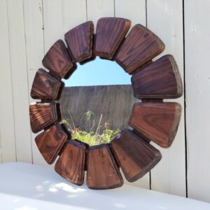 Beau miroir représentant un fleur datant des années 70, les pétales sont en bois verni. Des petits chocs et rayures sur le bois, légères rayures d'usage sur le miroir. Bon état général Diamètre total : 51 cm