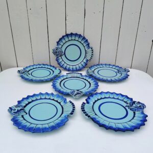 Six assiettes à poissons représentant certainement une sole , en faïence de Quimper, Signée Henriot, Quimper VL pour Victor Lucas. Assiettes datant des années 60-70. Idéales pour servir, poissons, crustacés,coquilages. Modèle très peu commun. Petites égrenures sur le bout de la bouche d'une assiette, traces de pernettes* en dessous. Bon état général. Diamètre : 21,5 cm *Pernettes : Une pernette est un support qui permet d'éviter que les poteries ne se touchent dans le four durant la cuisson. Ce qui laisse des endroit sans émail sur le dessous des céramiques.