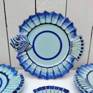 Six assiettes à poissons représentant certainement une sole , en faïence de Quimper, Signée Henriot, Quimper VL pour Victor Lucas. Assiettes datant des années 60-70. Idéales pour servir, poissons, crustacés,coquilages. Modèle très peu commun. Petites égrenures sur le bout de la bouche d'une assiette, traces de pernettes* en dessous. Bon état général. Diamètre : 21,5 cm *Pernettes : Une pernette est un support qui permet d'éviter que les poteries ne se touchent dans le four durant la cuisson. Ce qui laisse des endroit sans émail sur le dessous des céramiques.