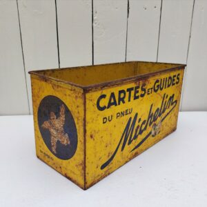 Ancienne boite en métal peint , publicitaire pour la marque Michelin. Elle servait à ranger les cartes et les guides michelin. Traces de corrosion, des rayures d'usage, manque de peinture.  Bel état pour une boite de son age. Dimensions : 33 x 14,5 x 17 cm