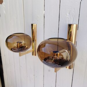 Paire d'appliques design Space âge par Gaetano Sciolari datant des années 60/70. Belle fabrication italienne en métal doré et globes ovoïdes en verre fumé. Piqûres sur le métal doré, petites traces d'usage sur les globes en verre Bon état général  - Dimensions : - Hauteur : 21,5 cm - Diamètre globe : 15 cm - Profondeur totale :  ~20 cm.