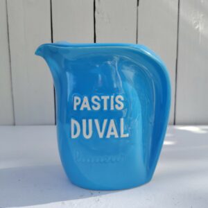 Pichet en céramique bleue publicitaire pour la marque d'anis Duval. Cigale en relief sur le coté de l'anse. Excellent état. Hauteur : 16,5 cm