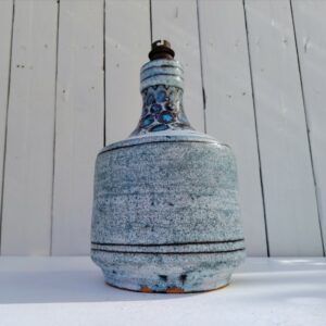 Pied de lampe en céramique crée par Danuta Le Hénaff. Dans les tons bleu pâle. Quelques défauts de cuisson sur le dessous sans gravité. Electrification d'origine. Feutre jaune sur le dessous pour éviter de rayer les meubles. Deux éclats au pied Bon état général Hauteur avec douille : 25 cm