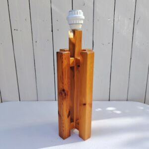 Pied de lampe en pin datant des années 80, forme géométrique. Très épurée et design. Des petits chocs, et rayures d'usage. Un éclat sur la douille. Bon état général. Hauteur avec douille : 42 cm 