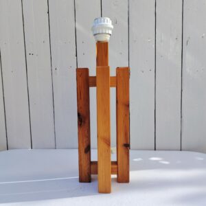 Pied de lampe en pin datant des années 80, forme géométrique. Très épurée et design. Des petits chocs, et rayures d'usage. Un éclat sur la douille. Bon état général. Hauteur avec douille : 42 cm 