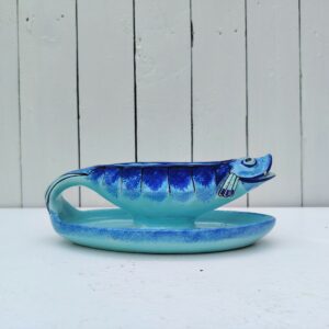 Saucière en faïence de Quimper à la forme de poisson, signée Henriot Quimper, VL pour Victor Lambertsur le dessous. Idéal pour pimper les tables d'été. Petites égrenures sur la gueule du poisson. Des petits défauts de cuisson Longueur : 23 cm Hauteur max : 9 cm