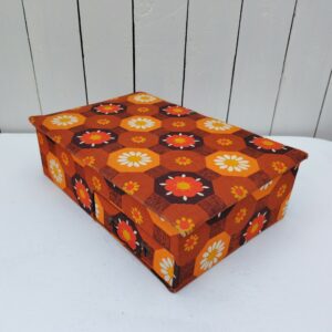    Boite à ouvrage ou couture datant des années 60-70 . Recouverte de tissu fleuri typique de cette époque. compartimentée en trois casiers à l'intérieur et d'un tiroir sur le devant Tâches intérieur sans gravité. Couleurs encore très fraîches. Déchirures de papier sur un des compartiments intérieur. Bon état général Longueur : 33 cm Largeur : 23 cm Hauteur : 10 cm