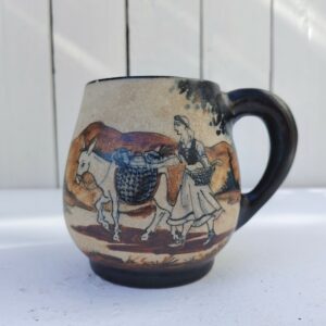 Tasse ou mug  provenant de la célèbre poterie de Ciboure, à décor d'une femme basque revenant du marché avec son ane. Signé sur le dessous M Fernandez pour Maria Fernandez. Très bon état. Hauteur : 10 cm Diamètre : 7 cm