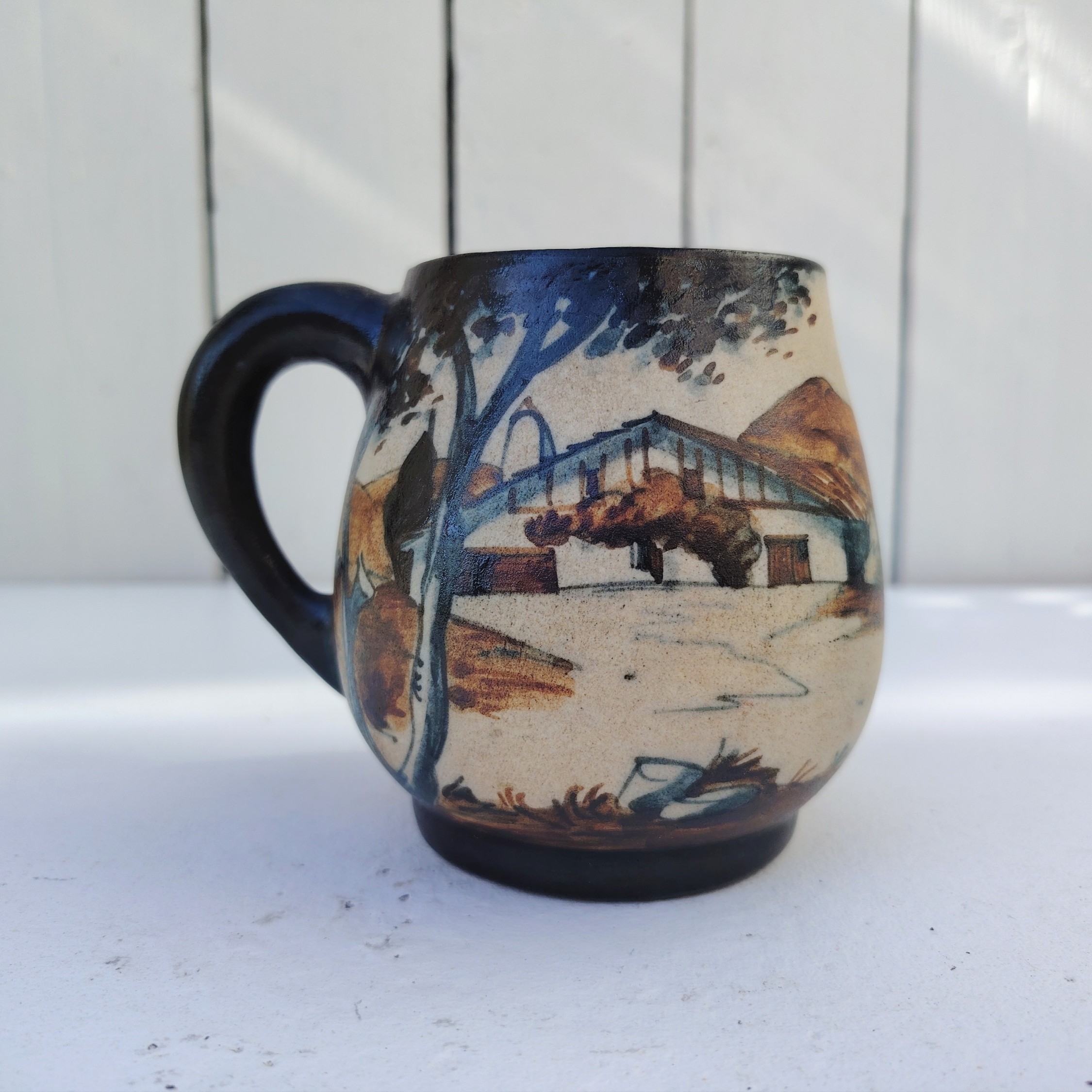 Tasse ou mug  provenant de la célèbre poterie de Ciboure, à décor d'une femme basque revenant du marché avec son ane. Signé sur le dessous M Fernandez pour Maria Fernandez. Très bon état. Hauteur : 10 cm Diamètre : 7 cm