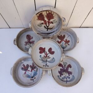 Six assiettes creuses en céramique, au décor de fleur, par Gustave Reynaud atelier le mûrier Vallauris. Elles ont toutes un décor différent et façonnées différemment. Des petits défauts de cuisson sans gravité. Deux poignées sur les cotés . Excellent état. Diamètre : 16 cm Hauteur : 5 cm