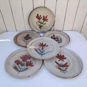 Six assiettes  plates en céramique, au décor de fleur, par Gustave Reynaud atelier le mûrier Vallauris. Elles ont toutes un décor différent et façonnées différemment. Excellent état. Diamètre : 24 cm