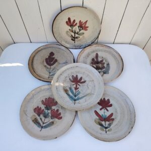 Six assiettes  plates en céramique, au décor de fleur, par Gustave Reynaud atelier le mûrier Vallauris. Elles ont toutes un décor différent et façonnées différemment. Excellent état. Diamètre : 24 cm