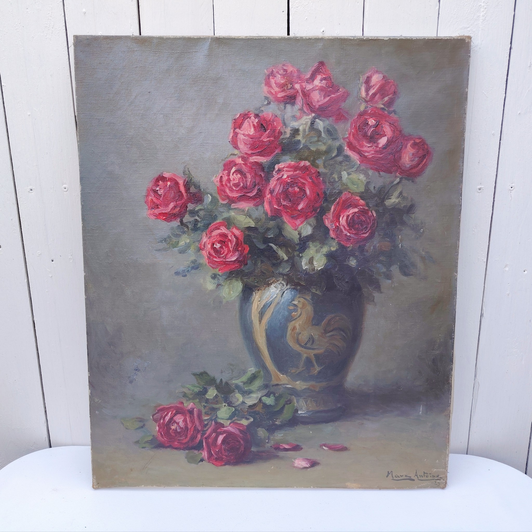 Tableau huile sur toile représentant un bouquet de roses dans un vase en porcelaine à décor de coq datant de 1929. Au premier plan deux roses en attente de rejoindre le bouquet . Signé Marc-Antoine.  Usures de toile sur le contour, des patchs de restauration à l'arrière. Un petit nettoyage à prévoir. Bon état général Dimensions : 61 x 50 cm