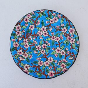 Petite assiette en céramique de Longwy, à décor floral émaillé fait à la main. Cachet de la manufacture sur le dessous. Bon état général. Diamètre : 19,5 cm