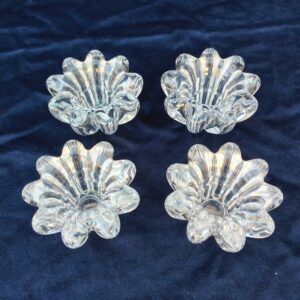 4 bougeoirs à la forme de fleurs. Idéal pour égayer vos tables de fête. Très bon état Diamètre total : 7,5 cm Hauteur 5 cm