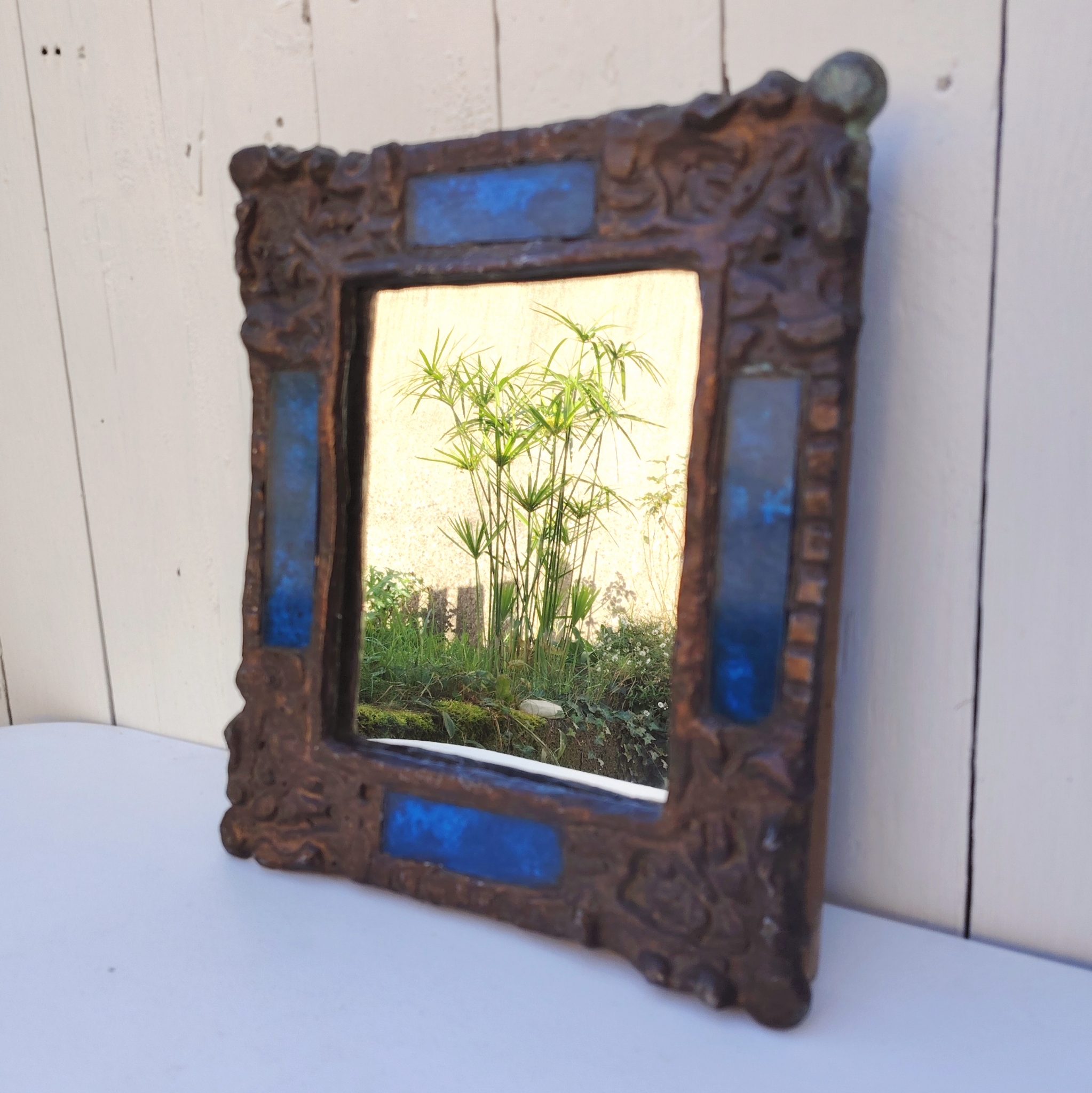 Miroir en plomb orné de carreaux en verre de couleur bleu. Datant des années 60-70 de l'artiste Irena Jaworska qui fut une élève de Line vautrin. Patine usée sur un coin. Un point d'accroche à l'arrière. Bon état général  Dimensions : 31 x 27 cm Miroir assez lourd (4kg)