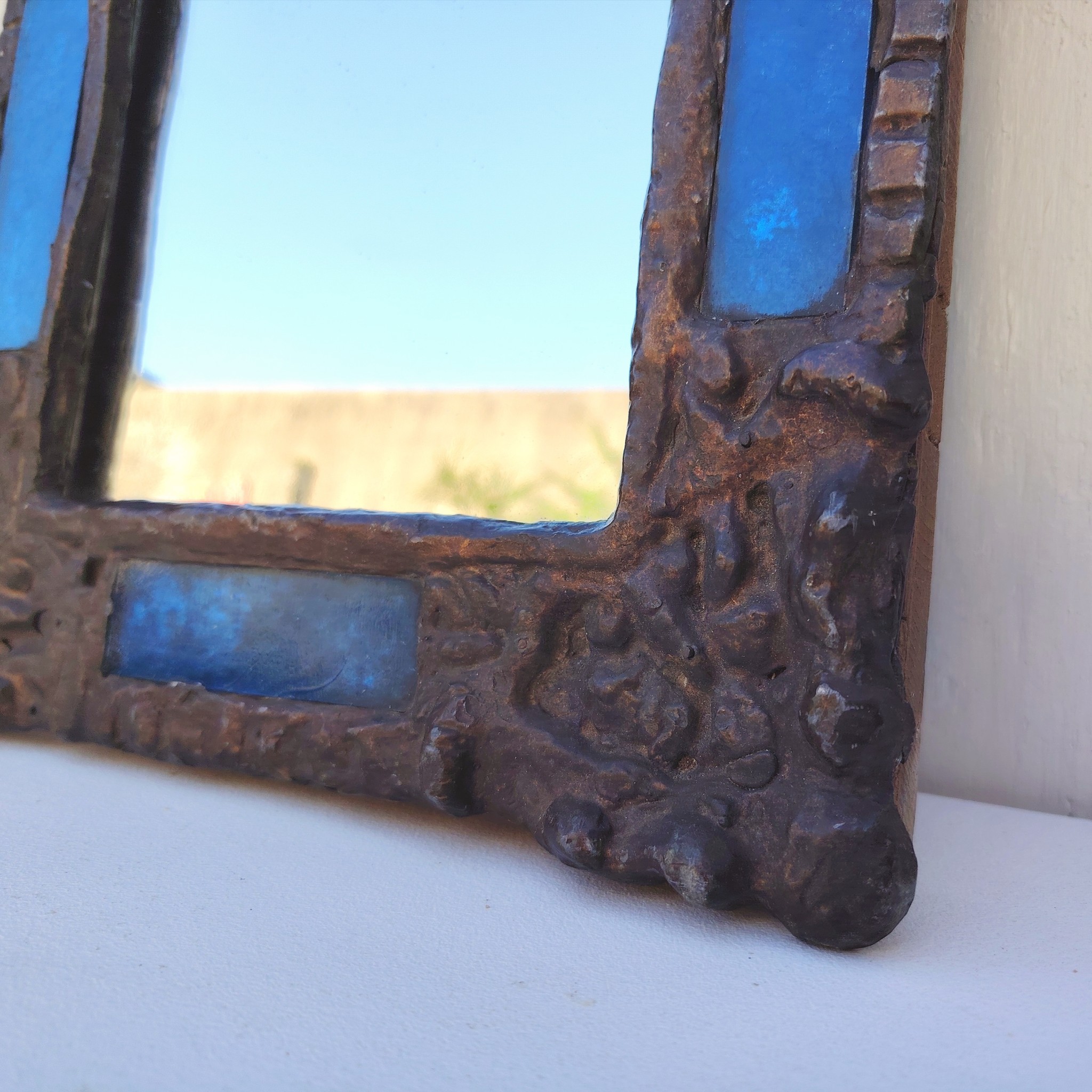 Miroir en plomb orné de carreaux en verre de couleur bleu. Datant des années 60-70 de l'artiste Irena Jaworska qui fut une élève de Line vautrin. Patine usée sur un coin. Un point d'accroche à l'arrière. Bon état général  Dimensions : 31 x 27 cm Miroir assez lourd (4kg)