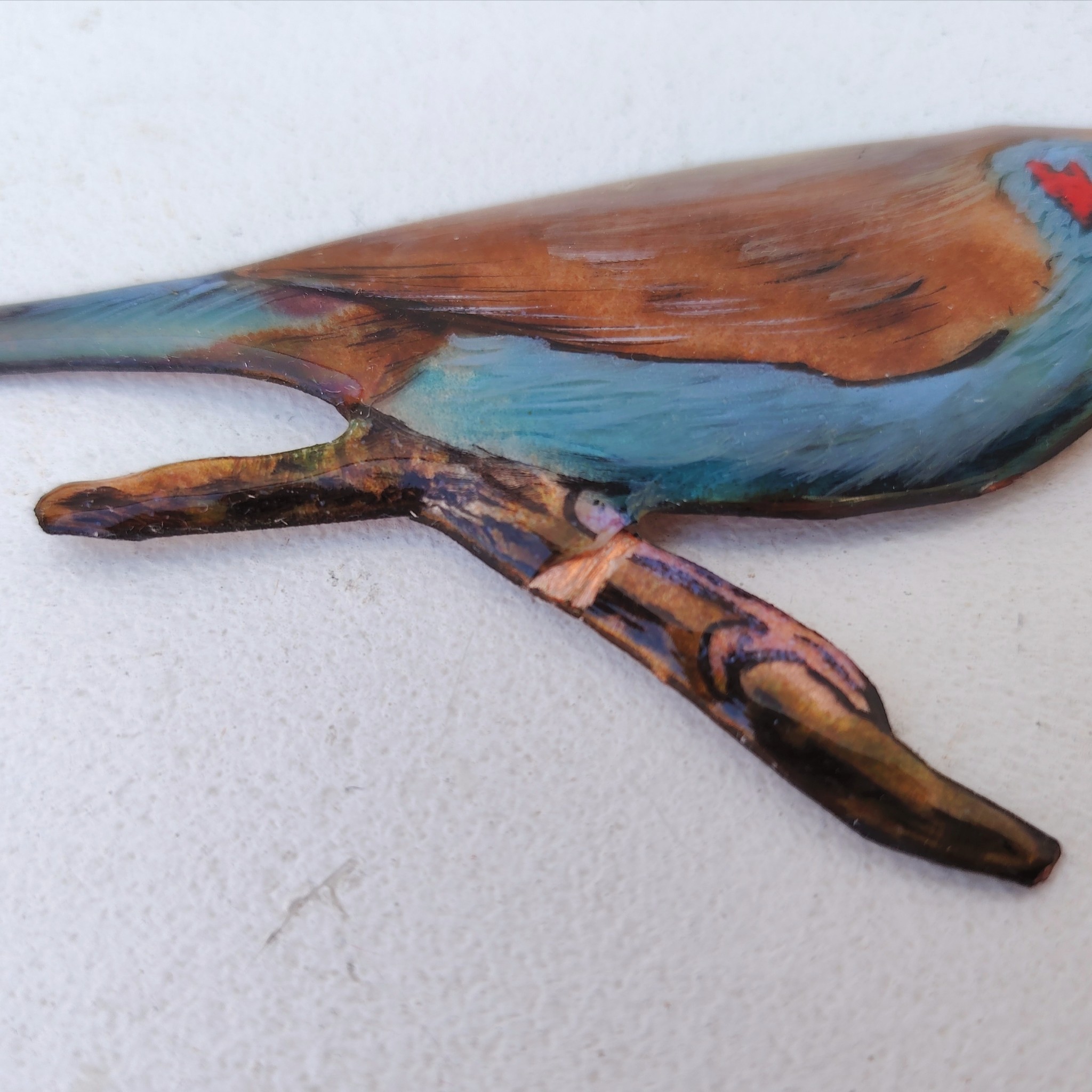 Oiseau représentant un cordon bleu à joues rouges, en émaux de Limoges sur cuivre. Datant des années 60-70. Un éclat d'émail sur la branche. Ne possède pas de point d'accroche. Bon état général. Dimensions : 11,5 x 5,5 cm