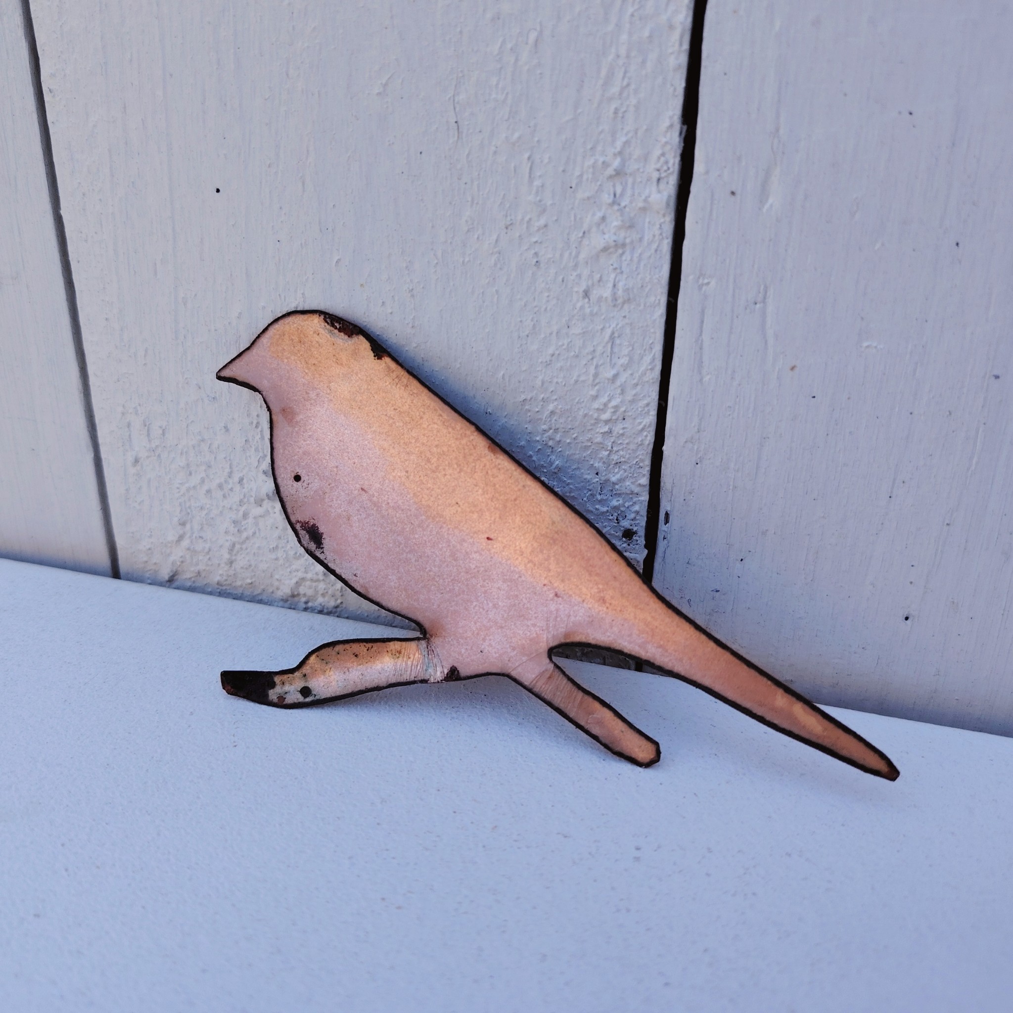 Oiseau représentant un cordon bleu à joues rouges, en émaux de Limoges sur cuivre. Datant des années 60-70. Un éclat d'émail sur la branche. Ne possède pas de point d'accroche. Bon état général. Dimensions : 11,5 x 5,5 cm