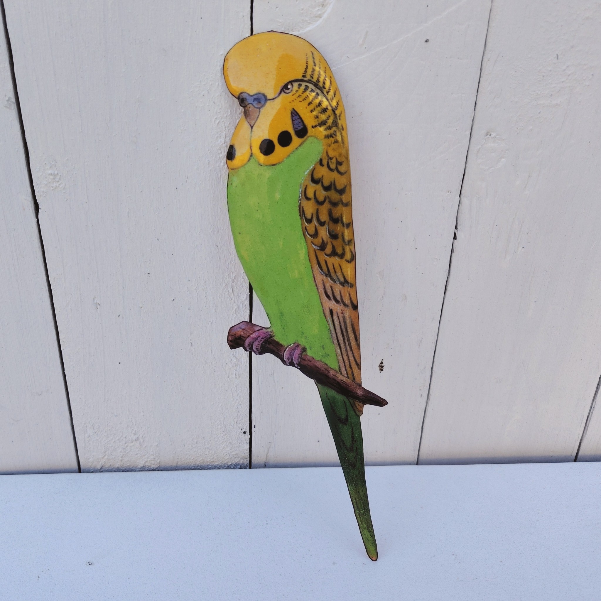 Oiseau représentant une perruche ondulée des bois, en émaux de Limoges sur cuivre. Datant des années 60-70. .Ne possède pas de point d'accroche. Une rayure au sur la branche Bon état général. Dimensions : 23,5 x 7,5 cm