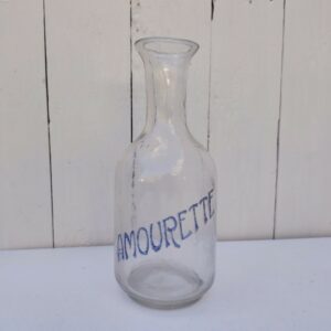 Ancienne carafe en verre soufflé publicitaire pour la marque d'anis Amourette. Trace de calcaire à l'intérieur, le mot Amourette est usé mais encore visible Bon état général Hauteur : 22 cm